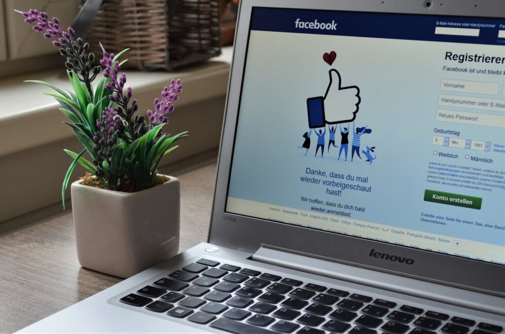 Laptop displaying Facebook login page next to a potted plant, symbolizing social media trends for small business owners in 2024