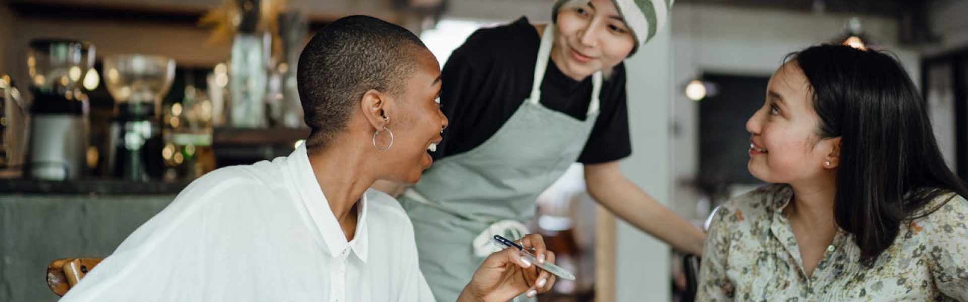 Three diverse small business owners in discussion at a cozy restaurant, embodying successful customer acquisition in Rockland County.